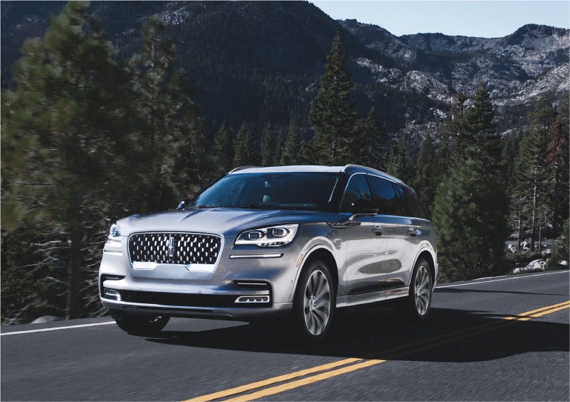 A 2023 Lincoln Aviator® Grand Touring SUV being driven on a winding road to demonstrate the capabilities of all-wheel drive | Preston Lincoln in Hurlock MD
