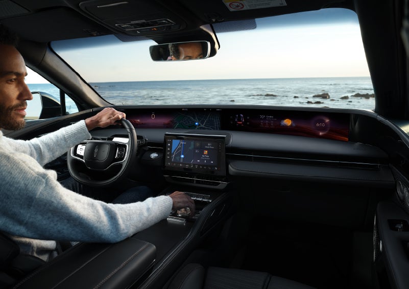 A driver of a parked 2024 Lincoln Nautilus® SUV takes a relaxing moment at a seaside overlook while inside his Nautilus. | Preston Lincoln in Hurlock MD