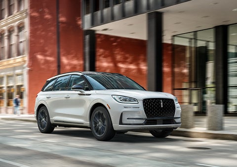 The 2024 Lincoln Corsair® SUV with the Jet Appearance Package and a Pristine White exterior is parked on a city street. | Preston Lincoln in Hurlock MD